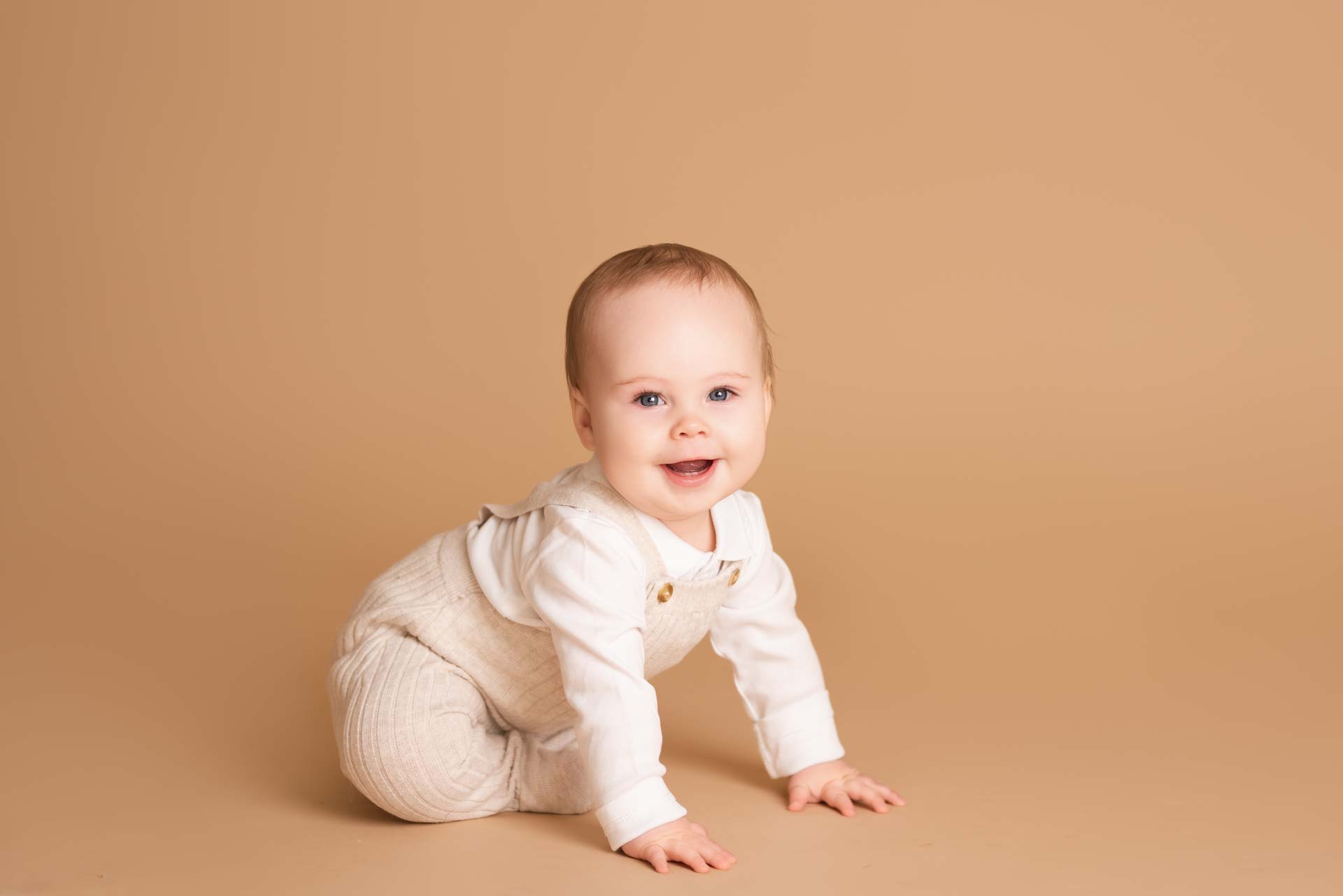Preschool Photoshoot Oxfordshire Baby boy sitting on the floor dressed in cream and white for his preschool photoshoot