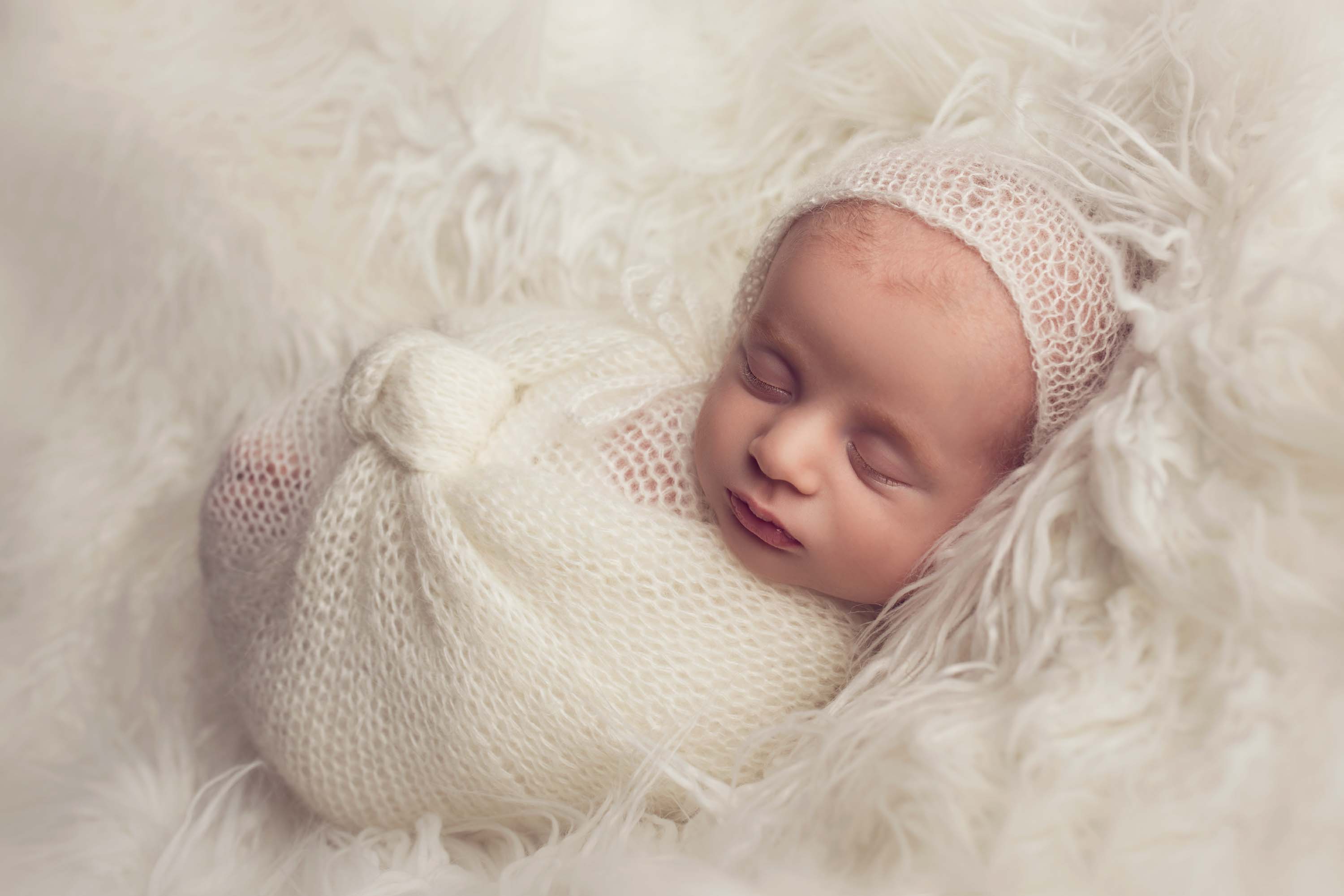 Swaddled baby boy asleep at his newborn photoshoot