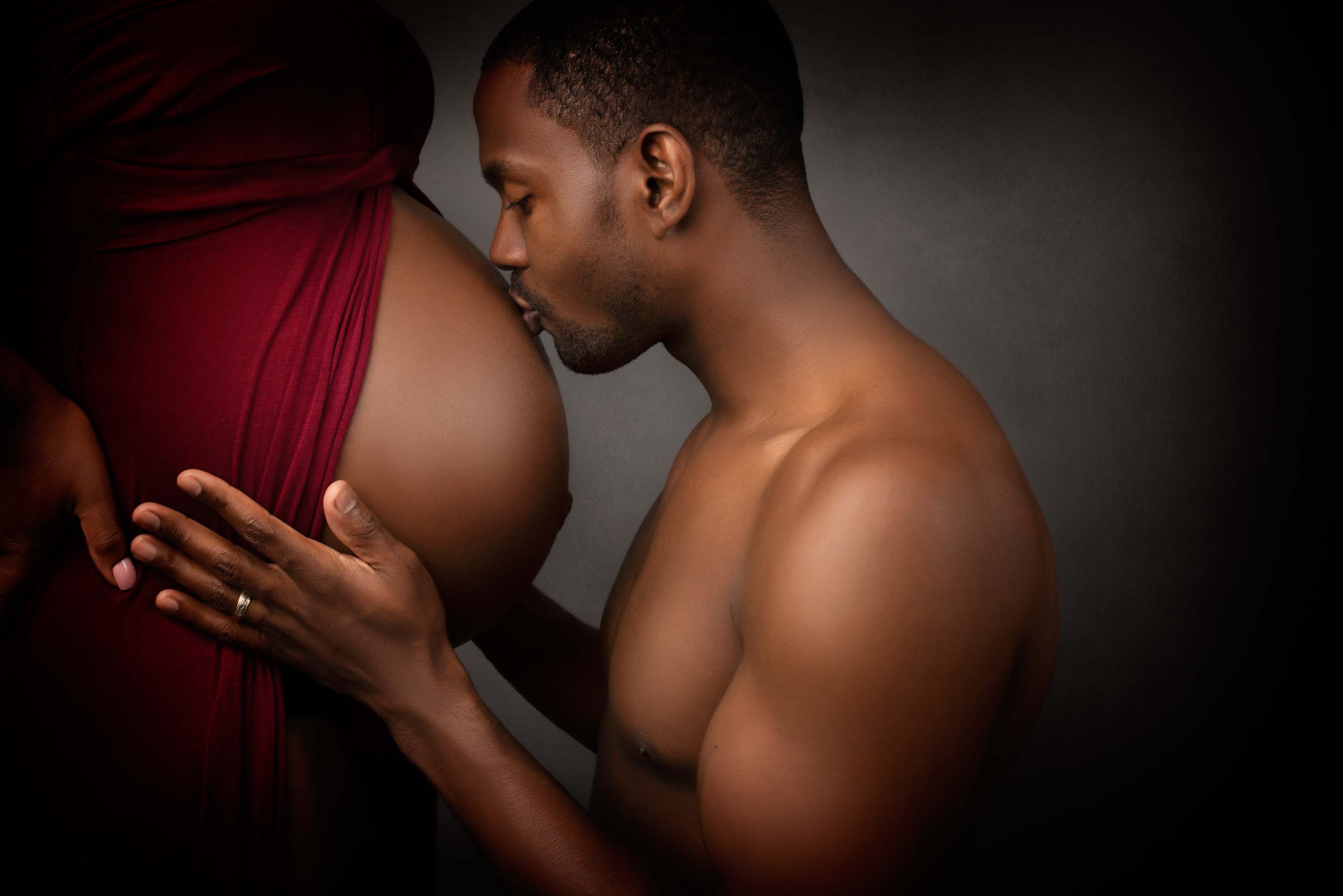 Man kissing the bump of his pregnant wife