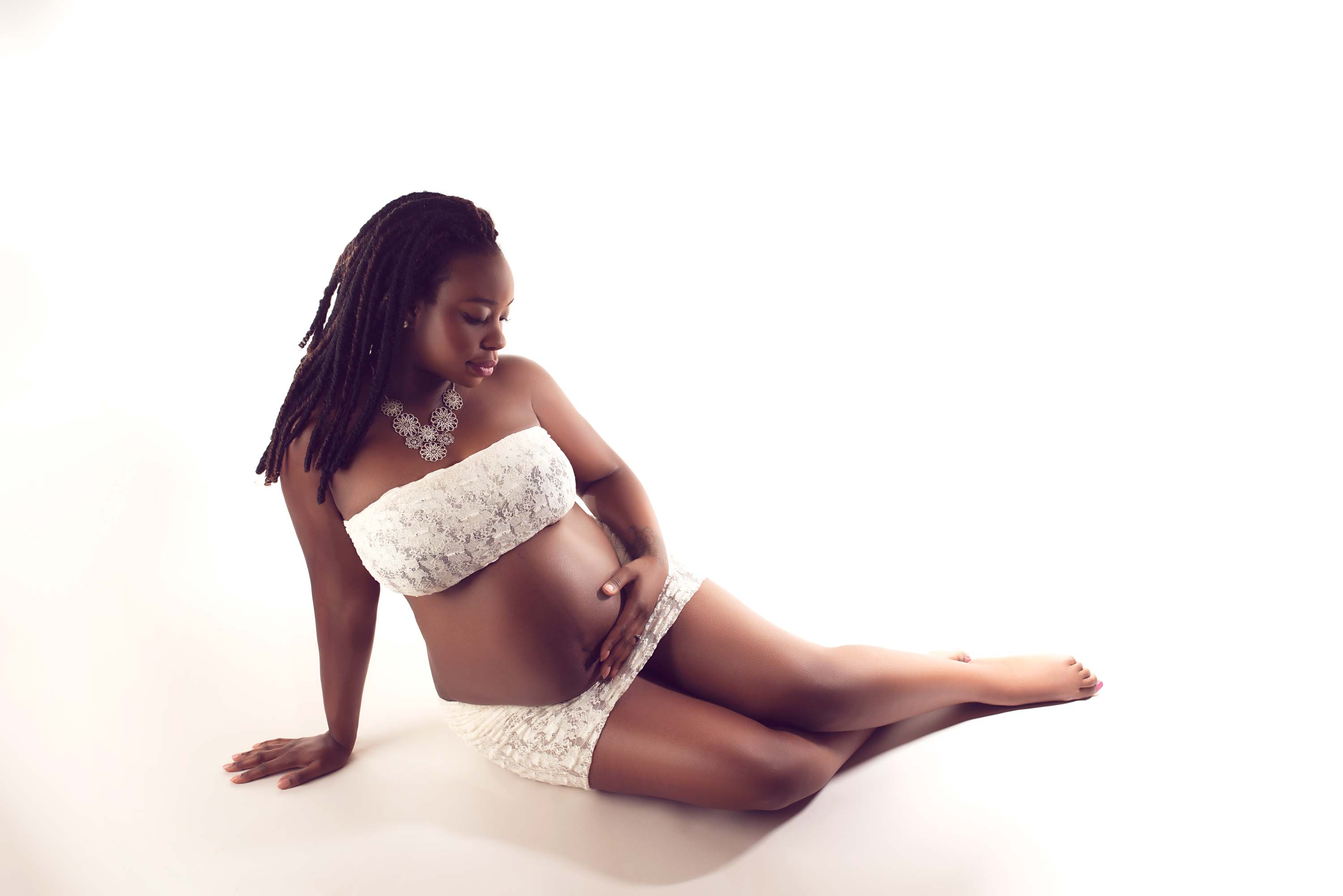 Pregnancy photography for a lady in white lacy top and bottom
