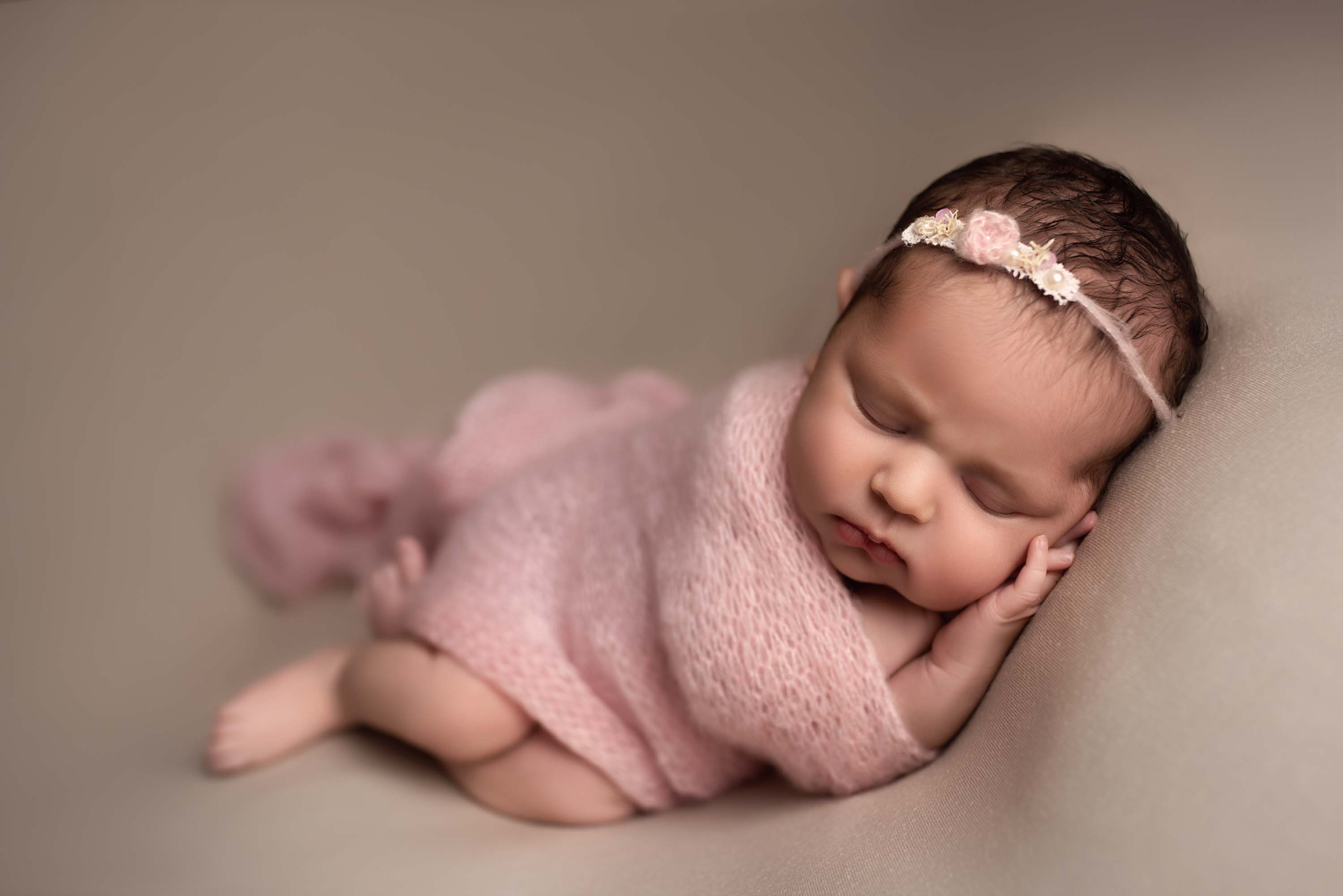 Newborn baby girl with pink headband and blanket