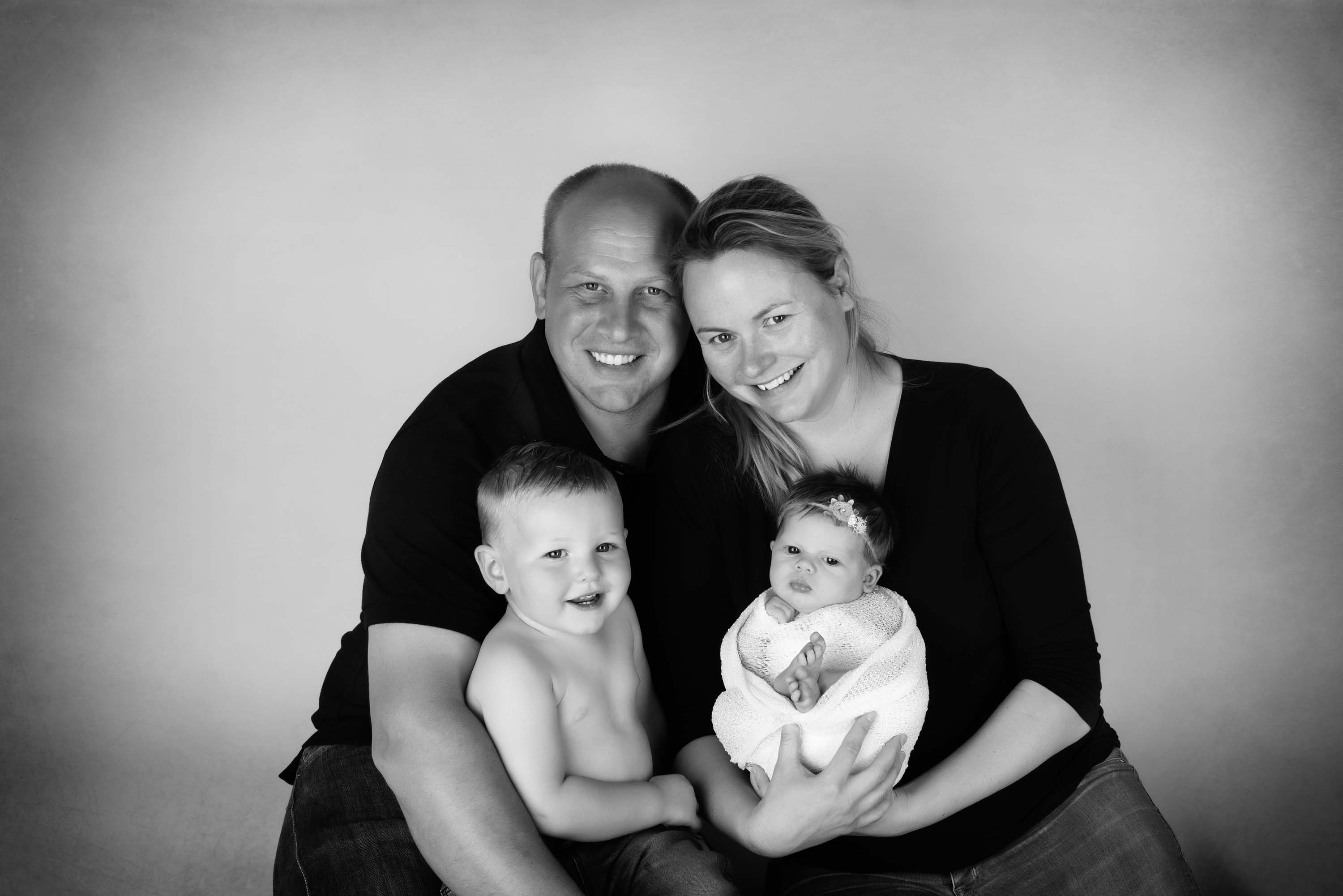 Black and white of a family of four from their baby photo shoot