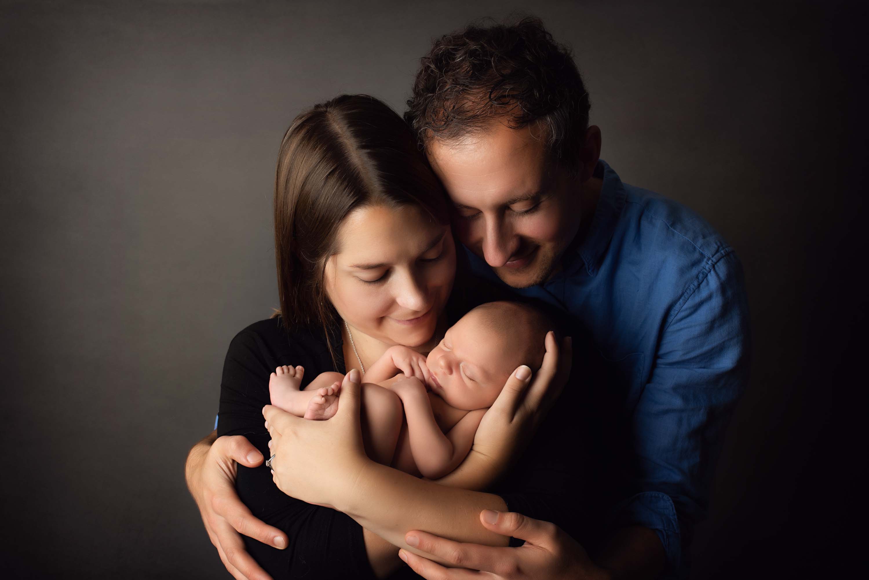 Family photograph with new baby boy being held by adoring mother