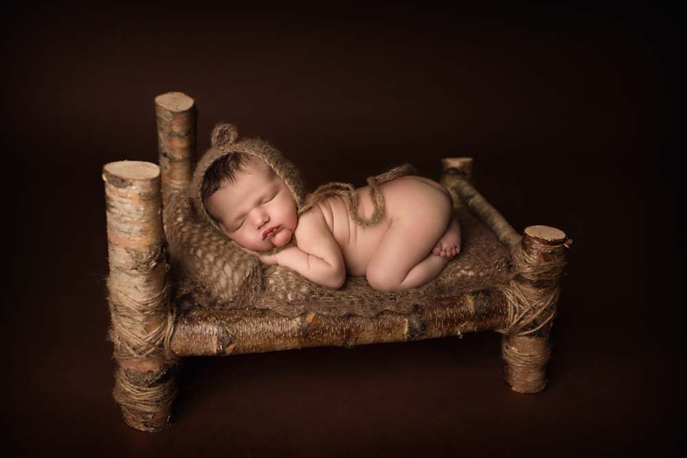 Baby boy sleeping on a wooden bed