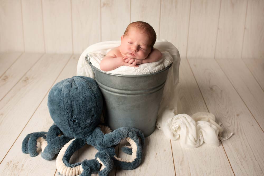Newborn Baby in a bucket with octopus for first photoshoot