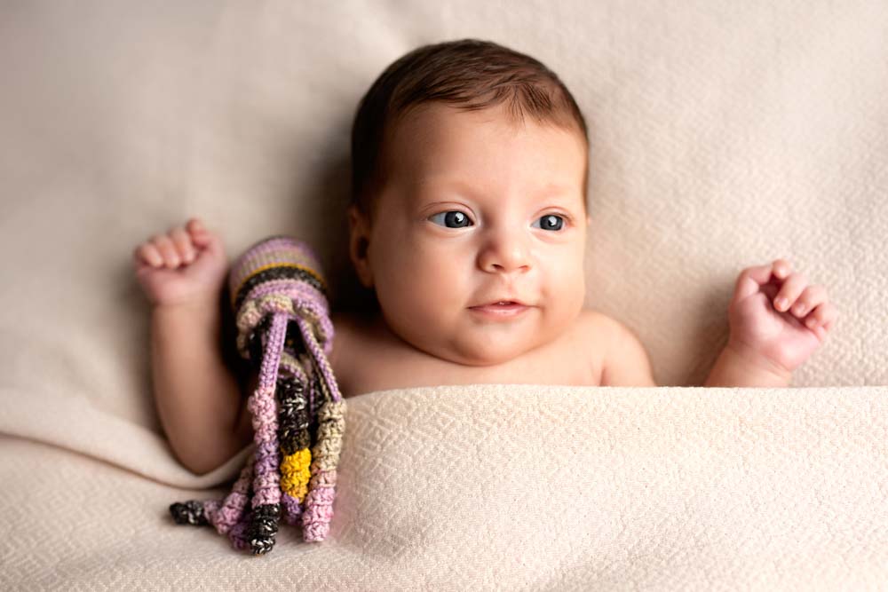 Premature baby cuddling a crochet octopus at her newborn photoshoot