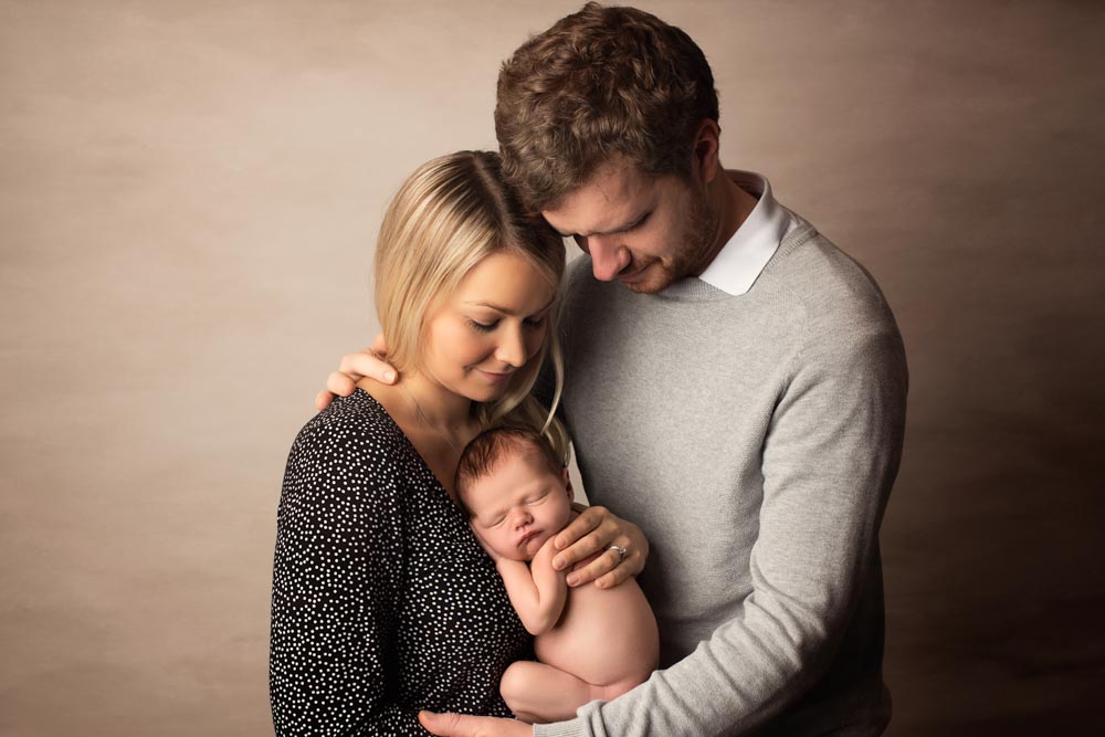 Young couple being photographed with their new baby