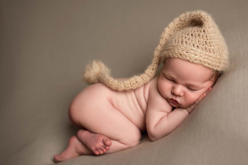 Baby boy on beanbag wearing long woolly hat