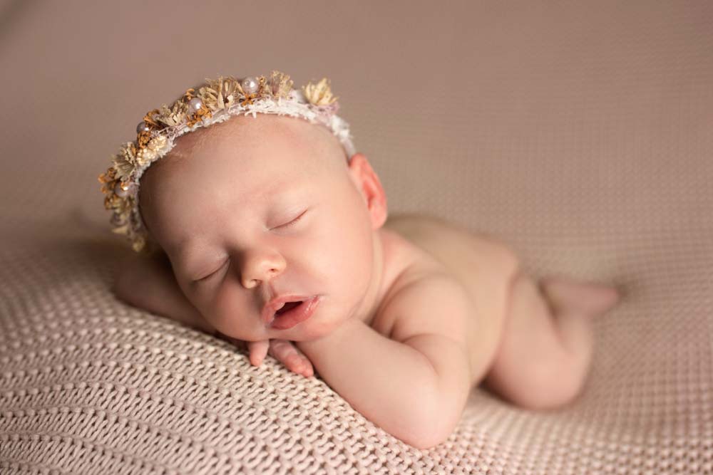 Baby girl wearing a floral headband at her baby photoshoot