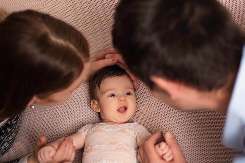 Little girl interacting with her parents at her newborn photoshoot
