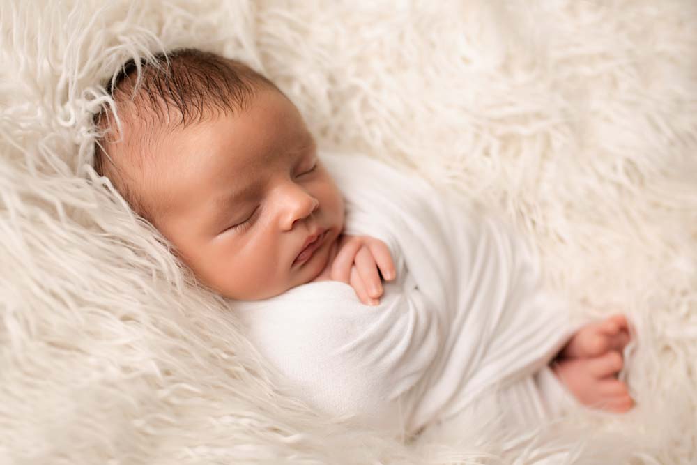 Soft fluffy blanket with newborn baby sunk into it