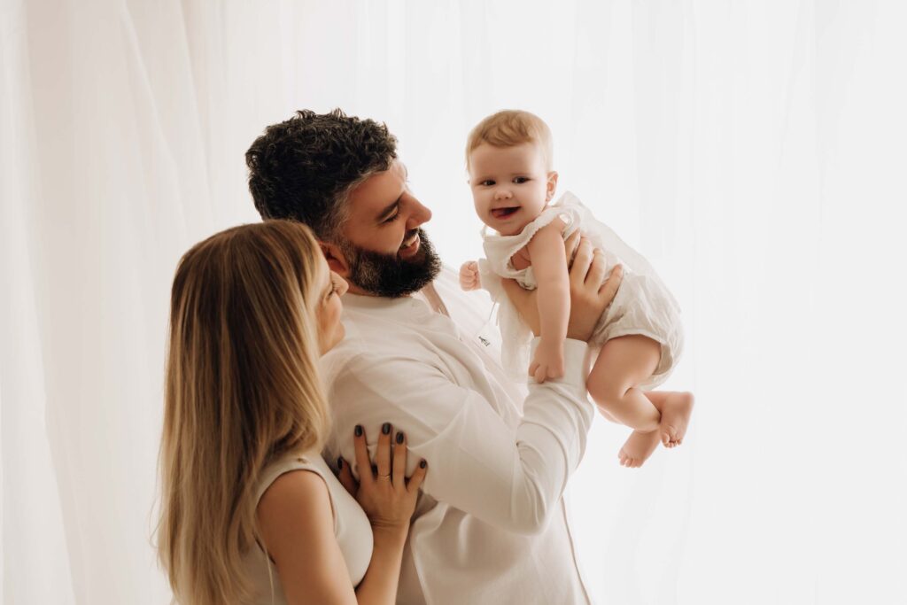 Couple enjoying being photographed with their six month old girl