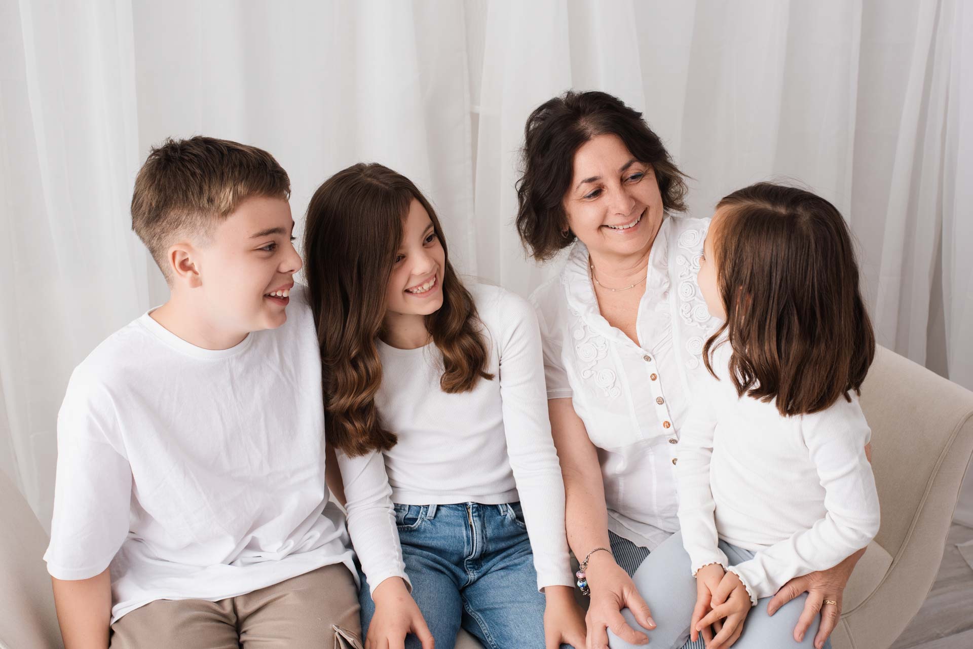 A grandmother is surrounded by her three grandchildren at a photoshoot to record her 70th birthday