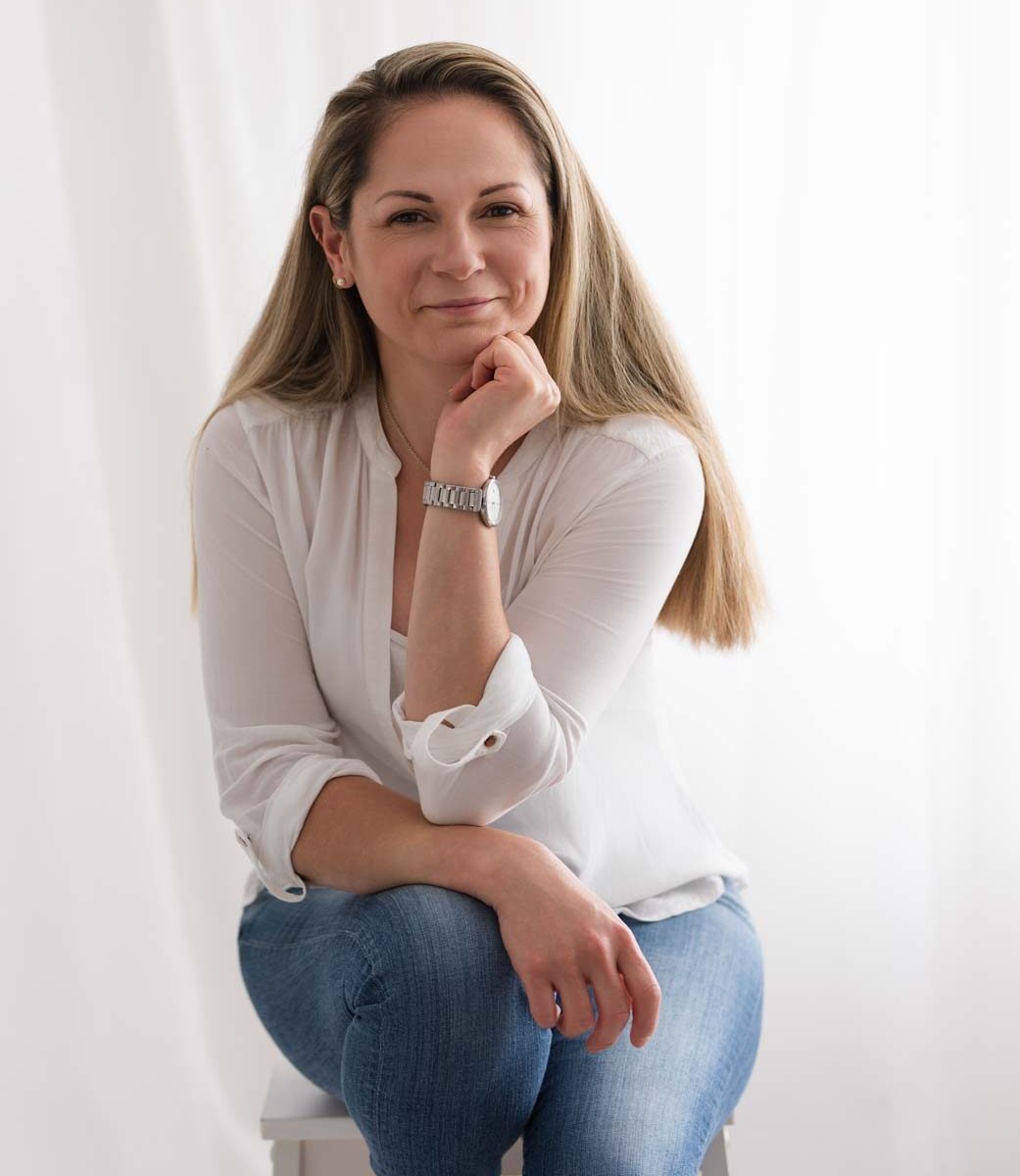 Business women with her head on her hand sits for her professional headshot