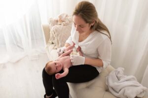Photographer holding baby during newborn photoshoot