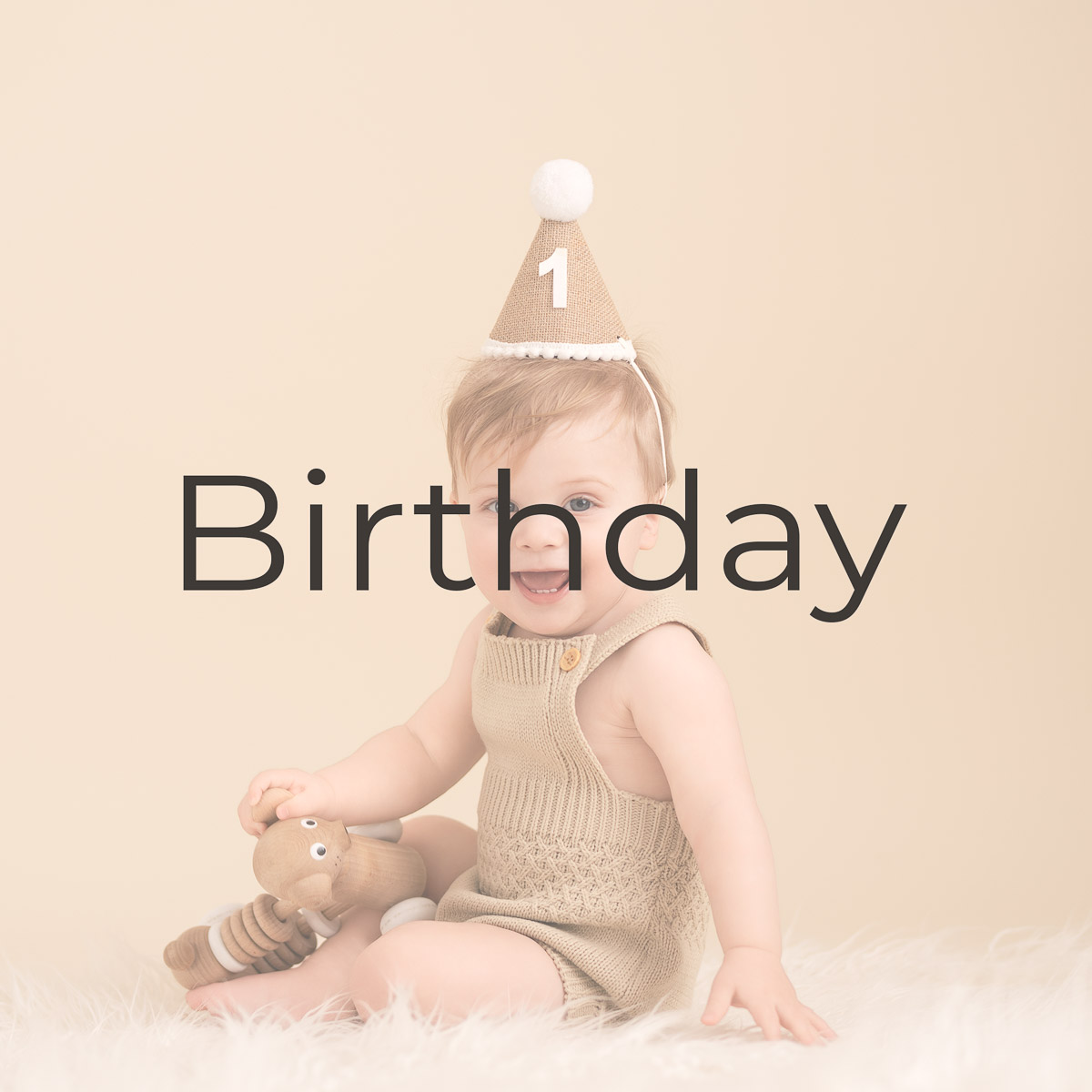 birthday boy wearing a party hat with the number one smiles at the camera for the family photographer Oxfordshire