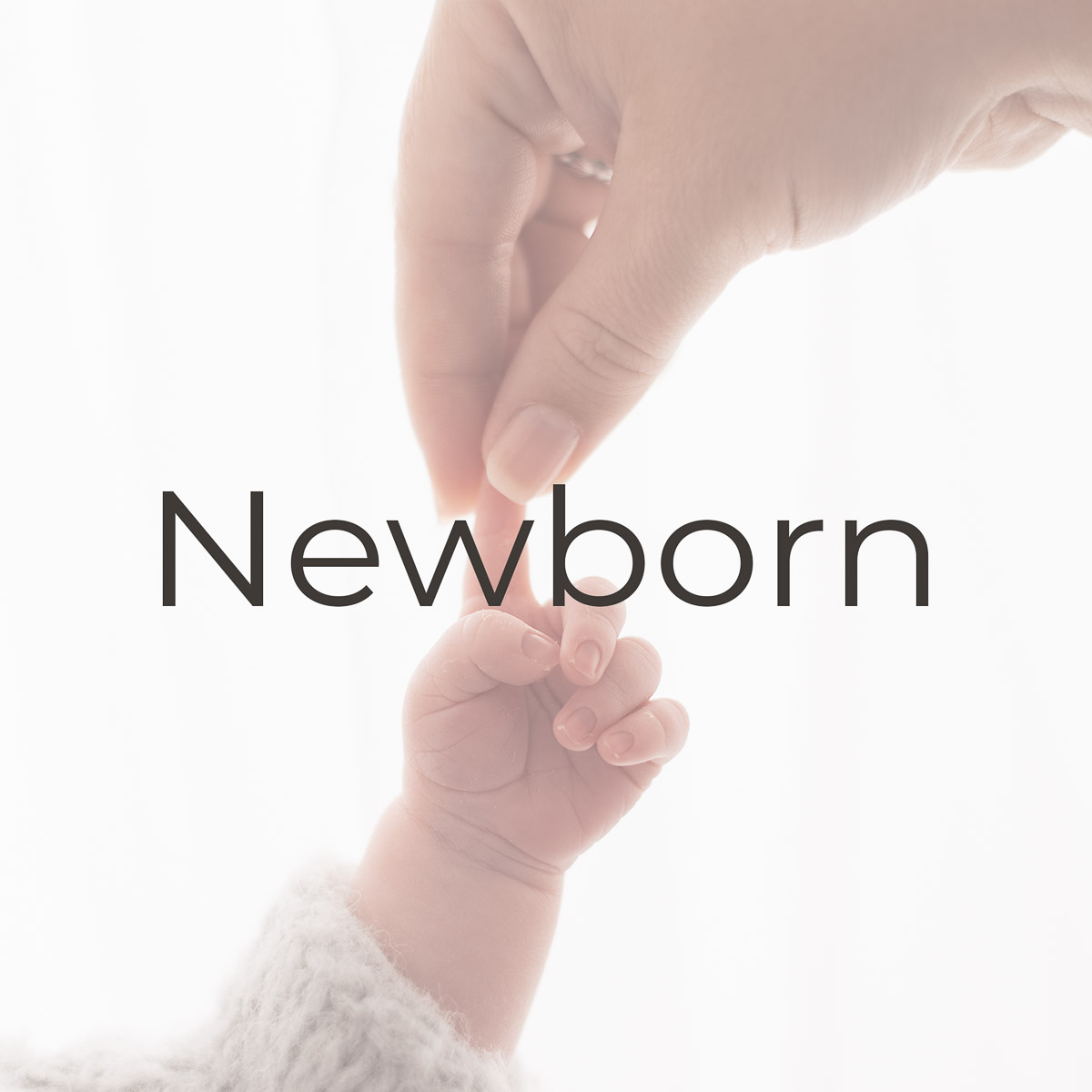 image of a mother holding up her newborn baby's finger taken by a family photographer Oxfordshire