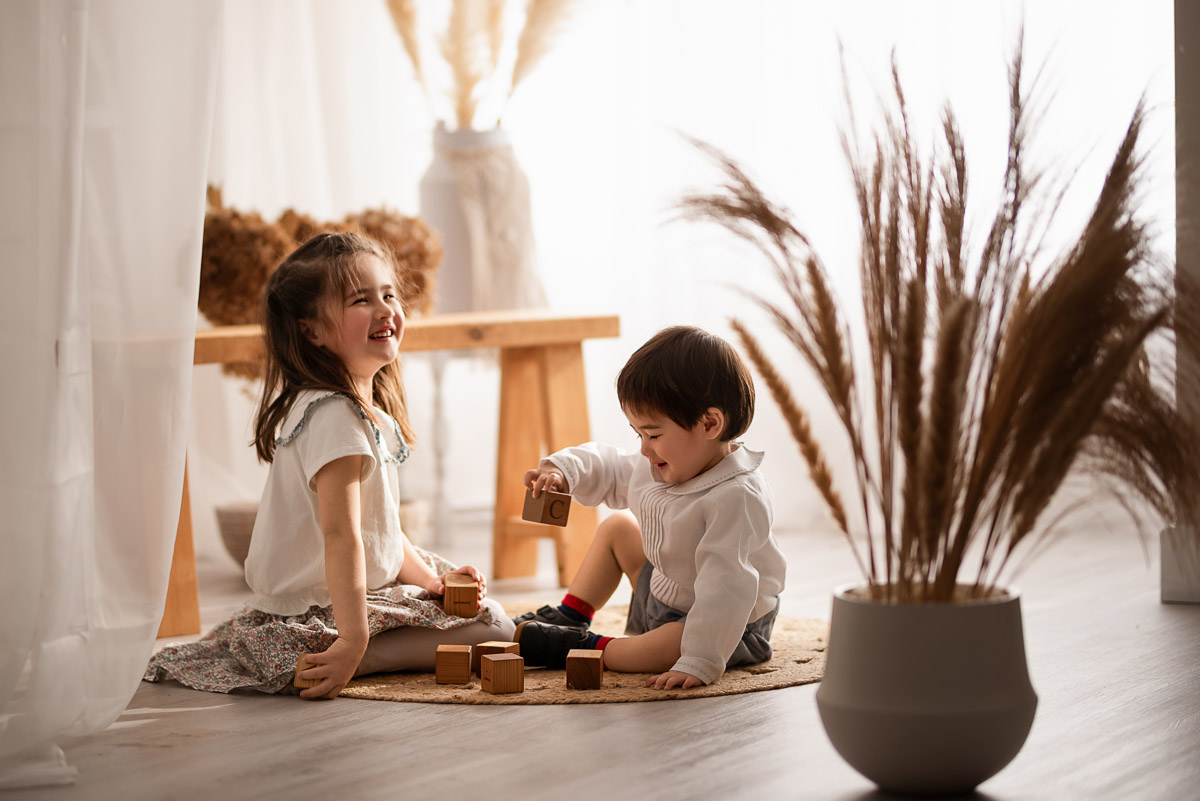 Brother and sister play with some wooden blocks during their family photoshoot