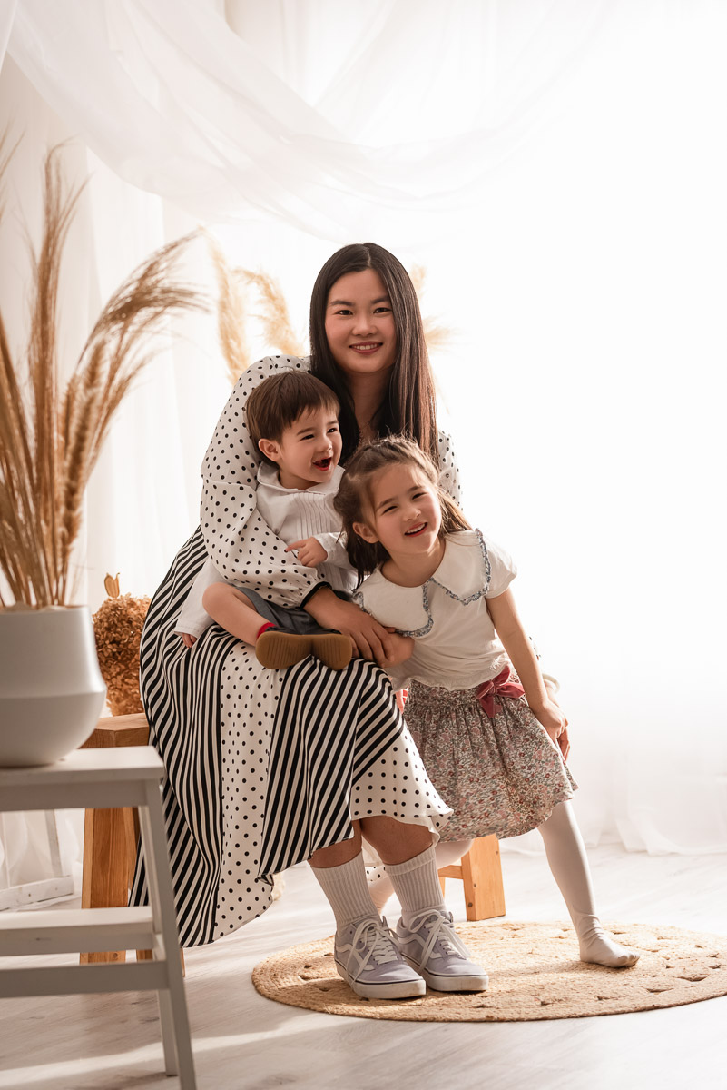 Mummy cuddling her son and daughter during their photoshoot