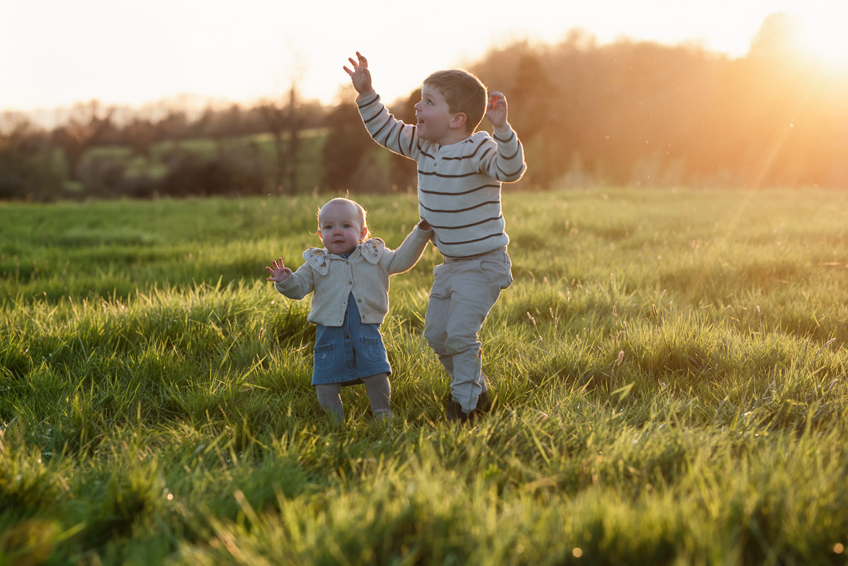 Two young siblings laughing together outdoors in Oxfordshire