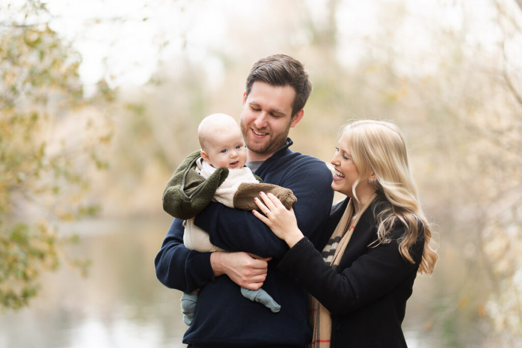 Mother and father smile at their son for this family photographer in Oxfordshire