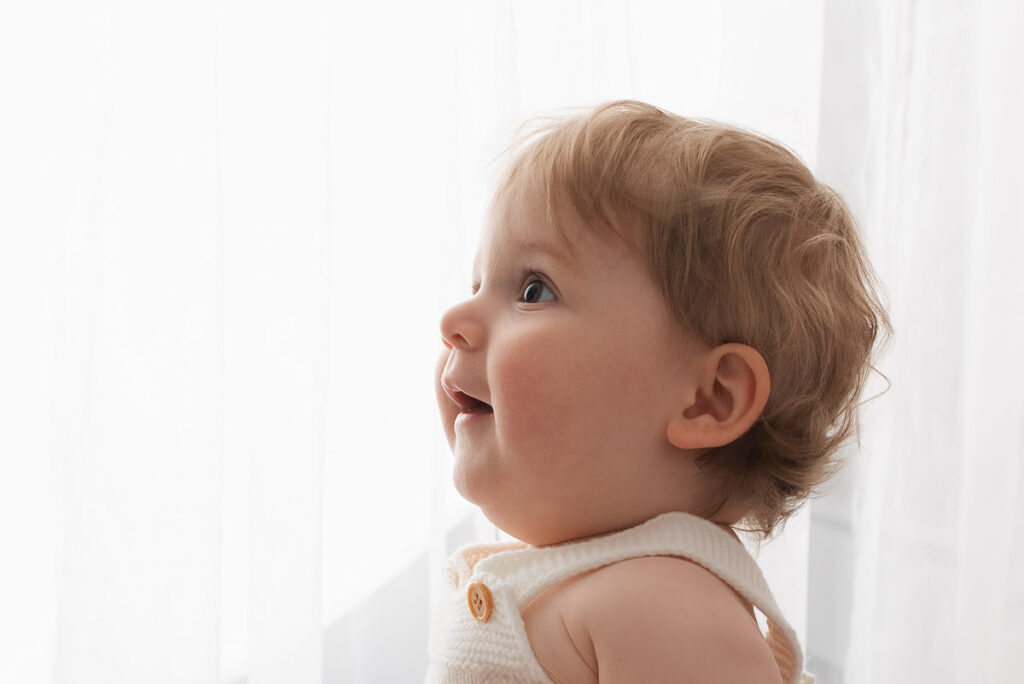 Close photo of baby boy with his eyes wide open against a white background