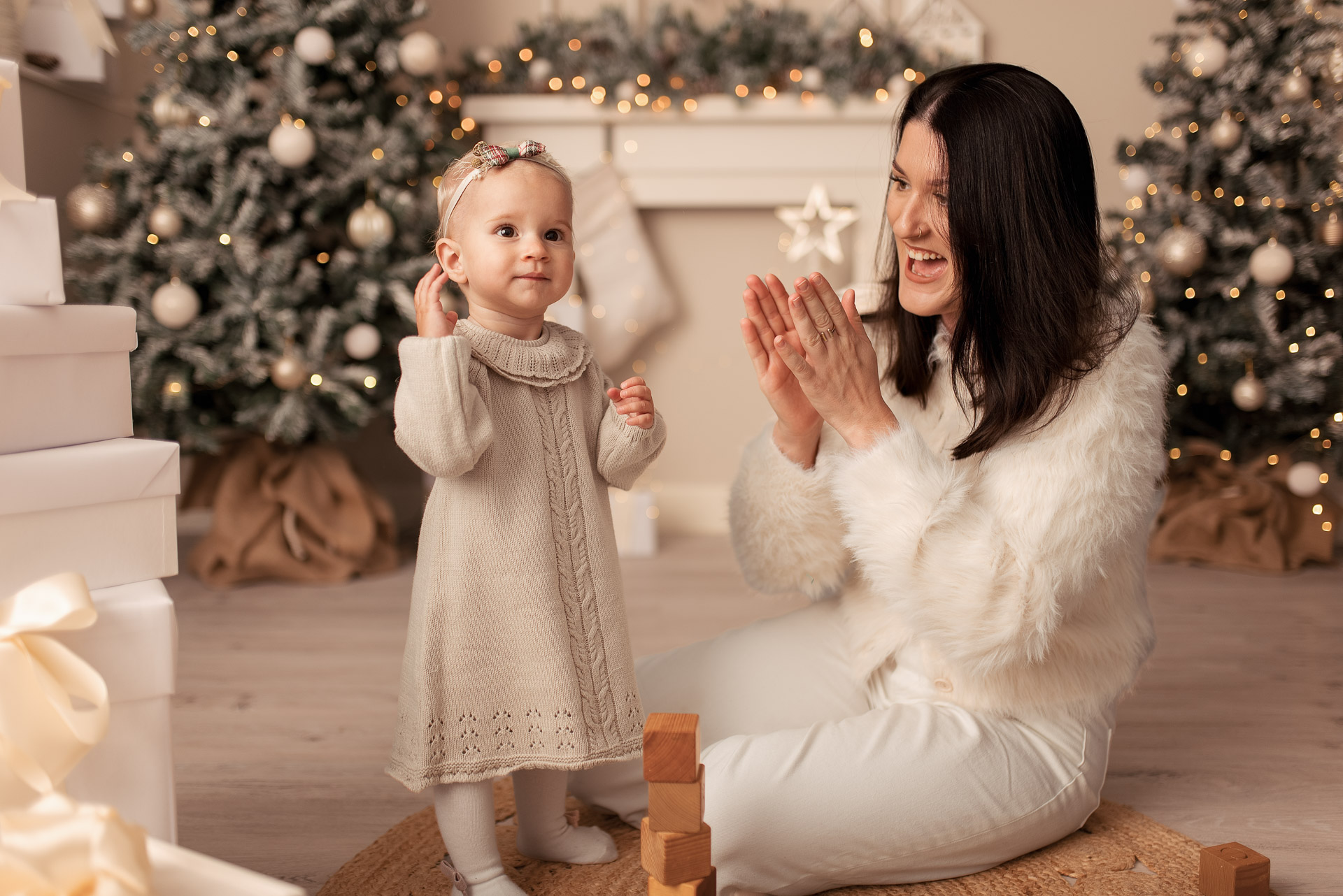 Mummy claps her hands during her Christmas family photoshoot with her daughter
