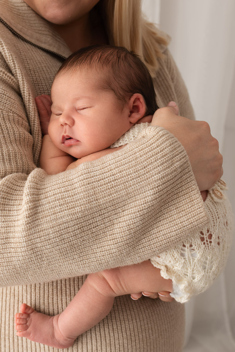 Baby girl is held tightly in her mothers arms for comfort